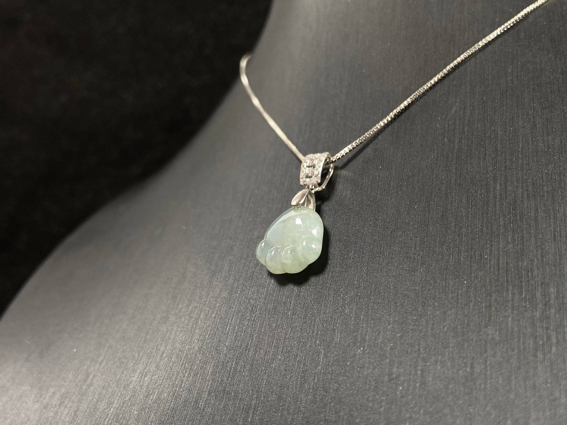 A light green jadeite cat paw pendant.