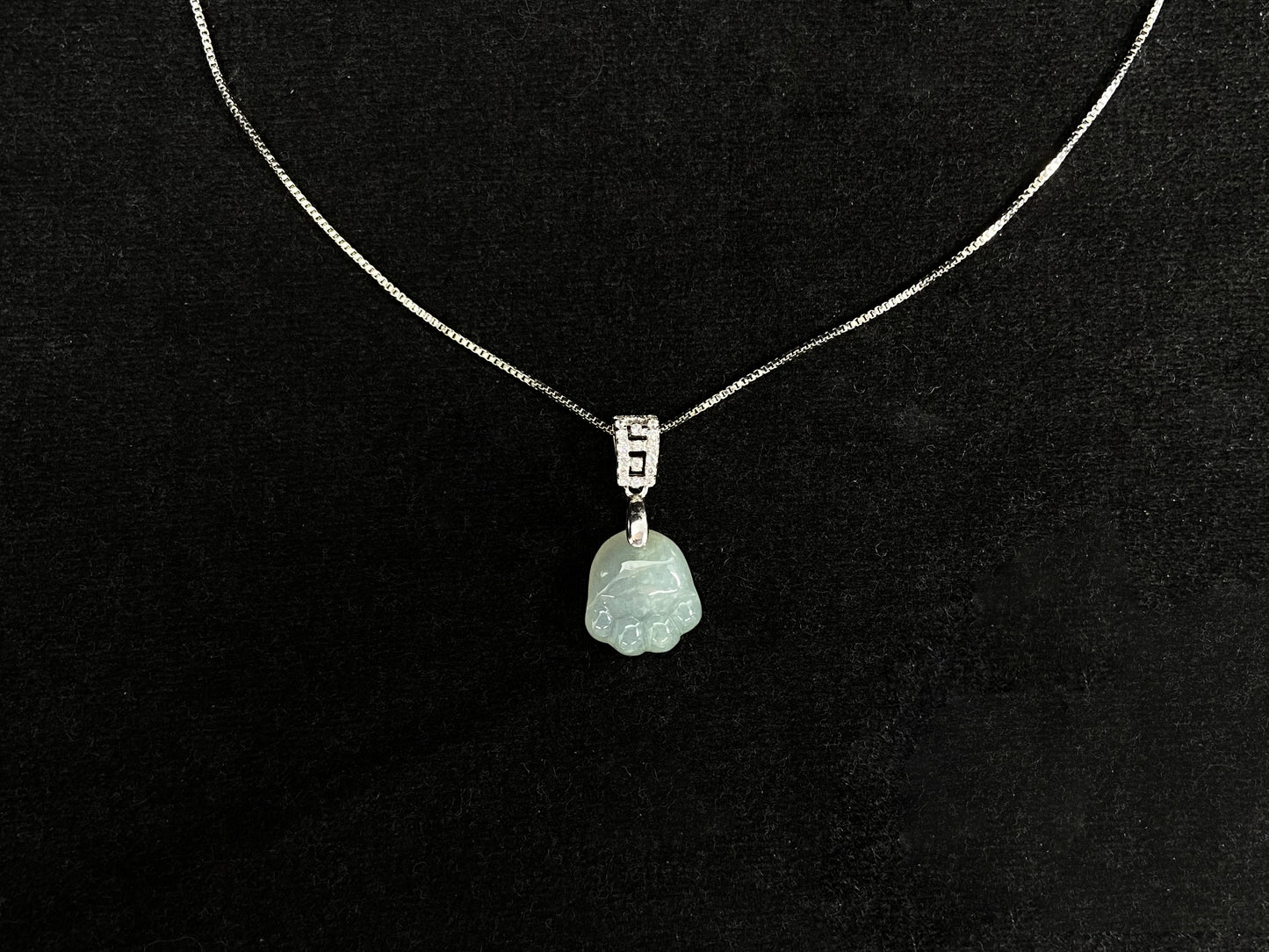 A light green jadeite cat paw pendant.