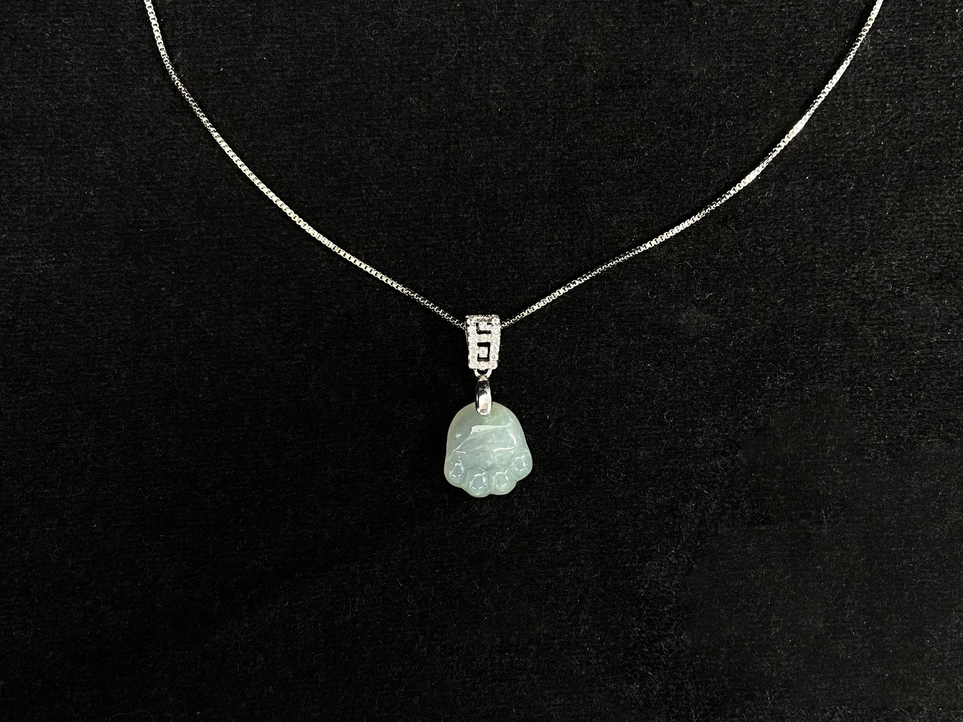 A light green jadeite cat paw pendant.