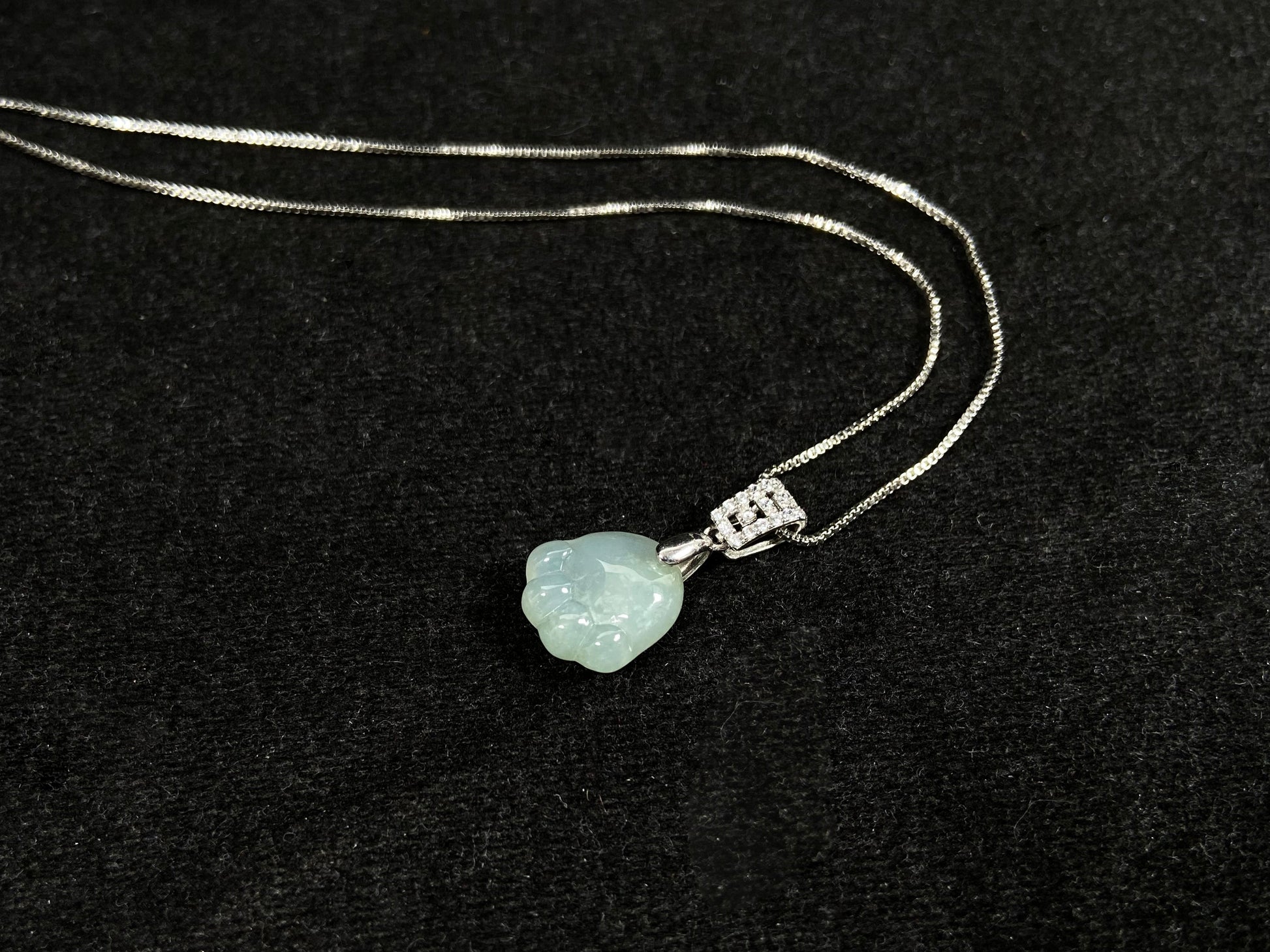 A light green jadeite cat paw pendant.