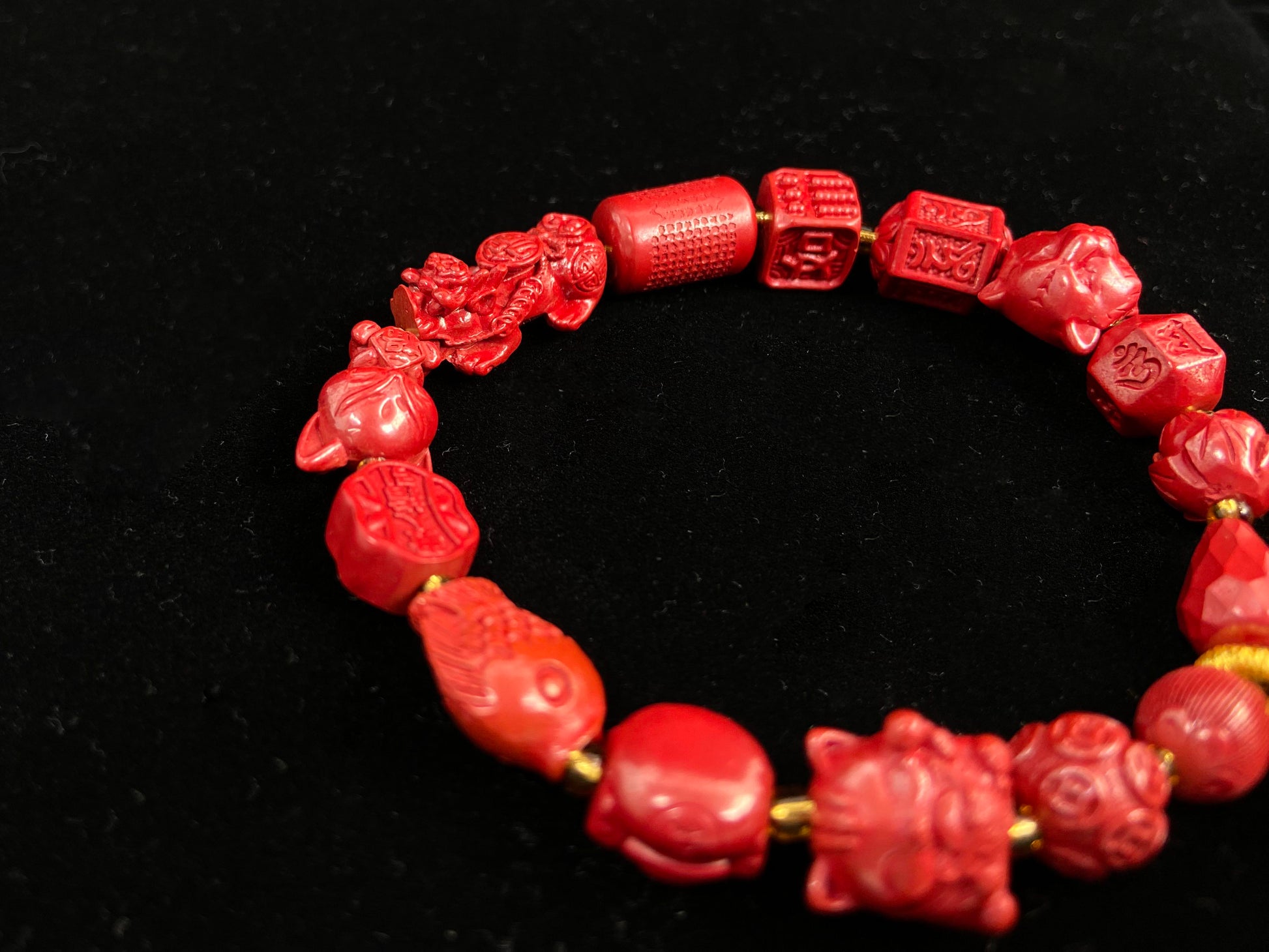 This cinnabar bracelet features various beads, such as coins, guardian lions, nine-tailed foxes, and more.