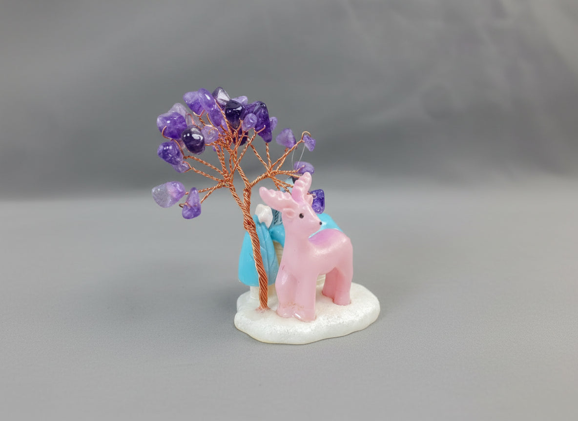 An amethyst crystal tree accompanied by a pink deer and a white cottage with a blue roof.