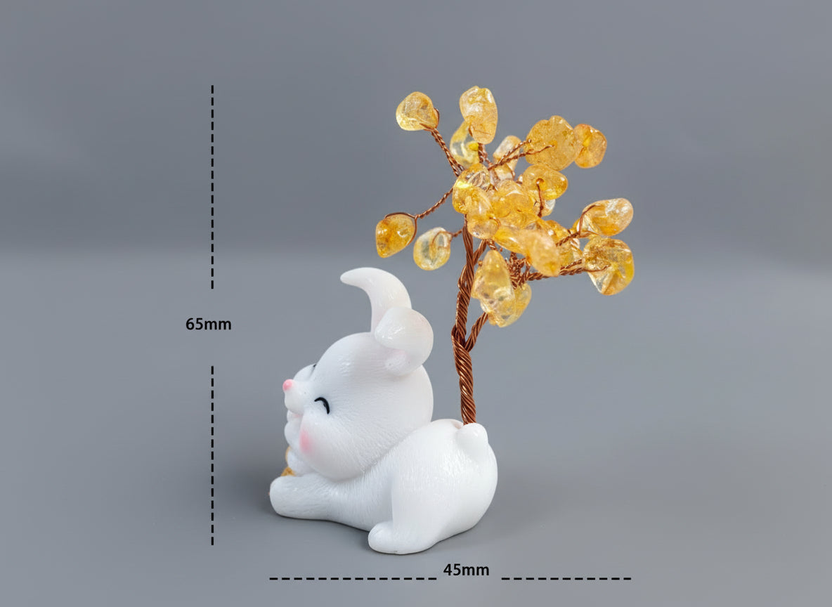 A citrine tree is set on a white rabbit holding several coins.