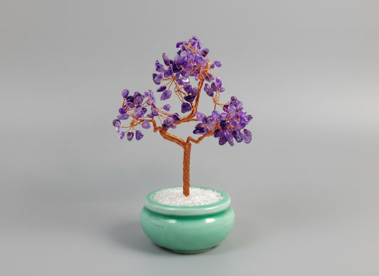 A amethyst crystal tree in a green pot.