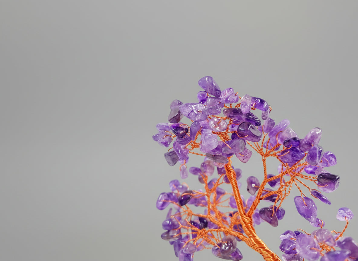 A amethyst crystal tree in a green pot.