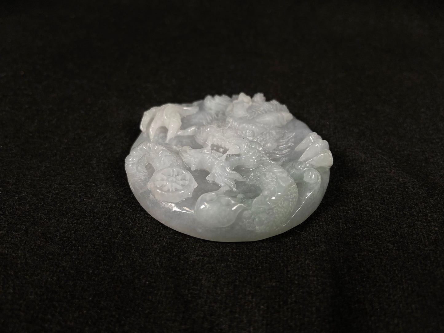 A creamy white jadeite disc carved with a dragon.
