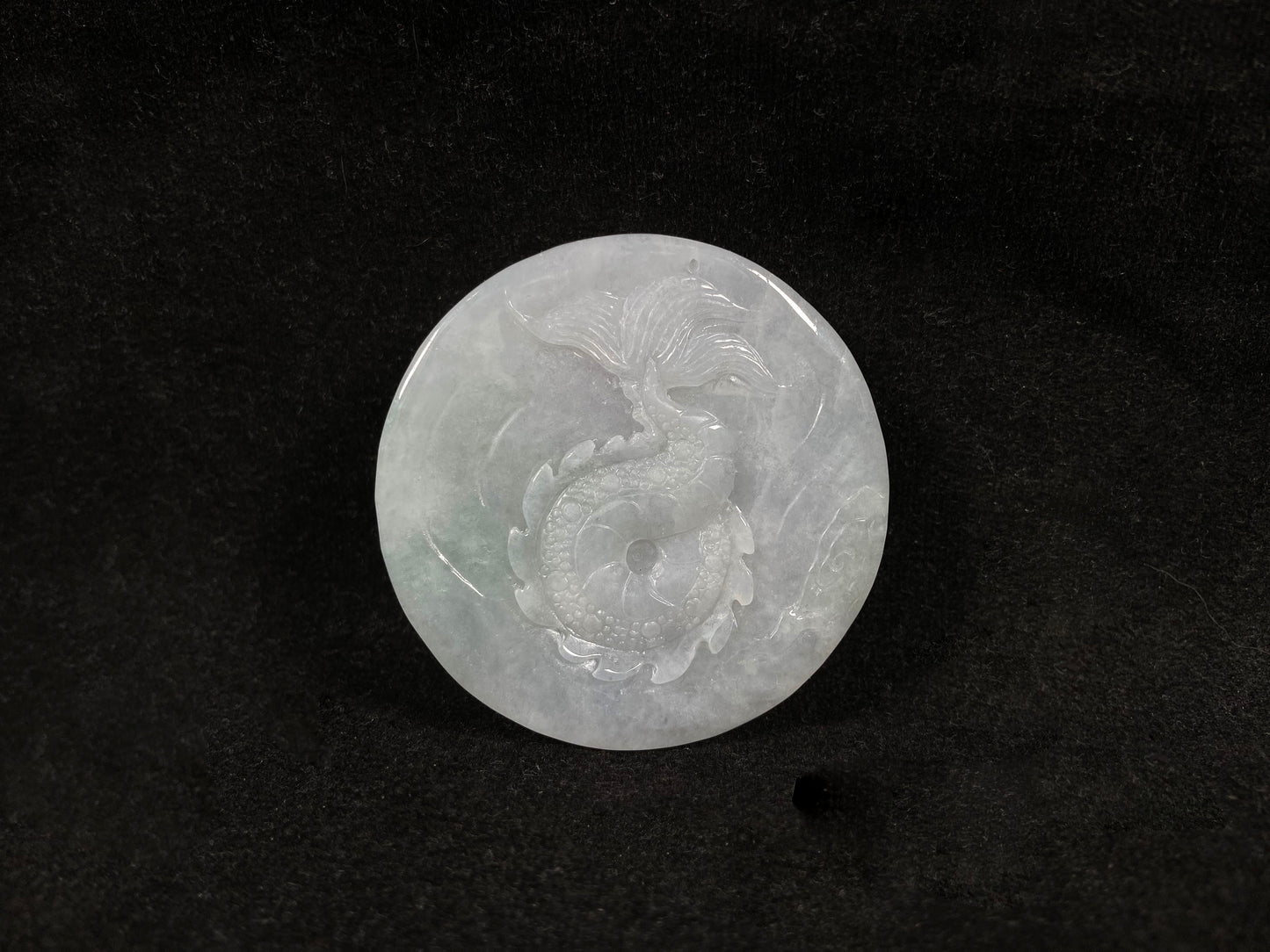 A creamy white jadeite disc carved with a dragon.