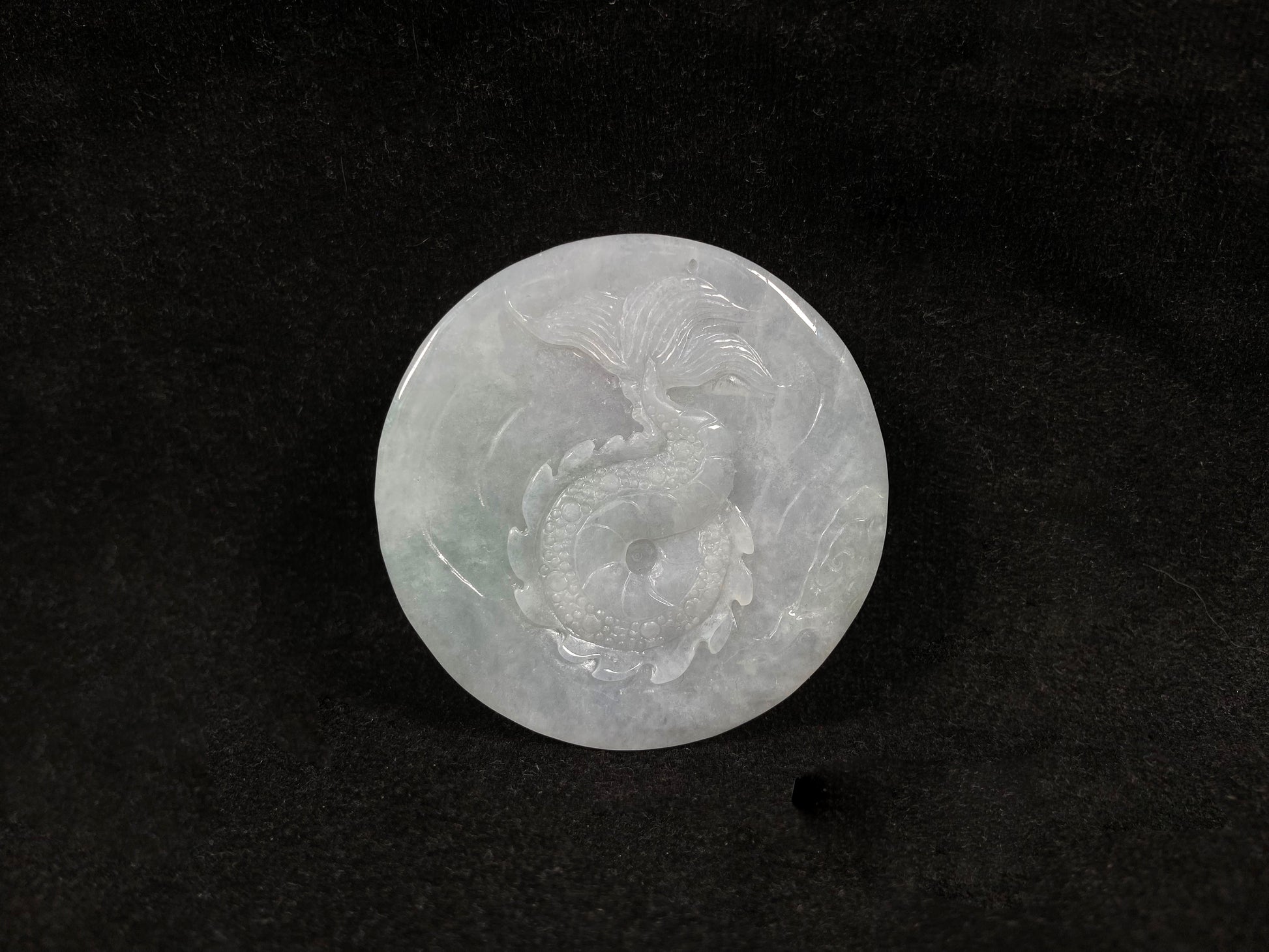 A creamy white jadeite disc carved with a dragon.