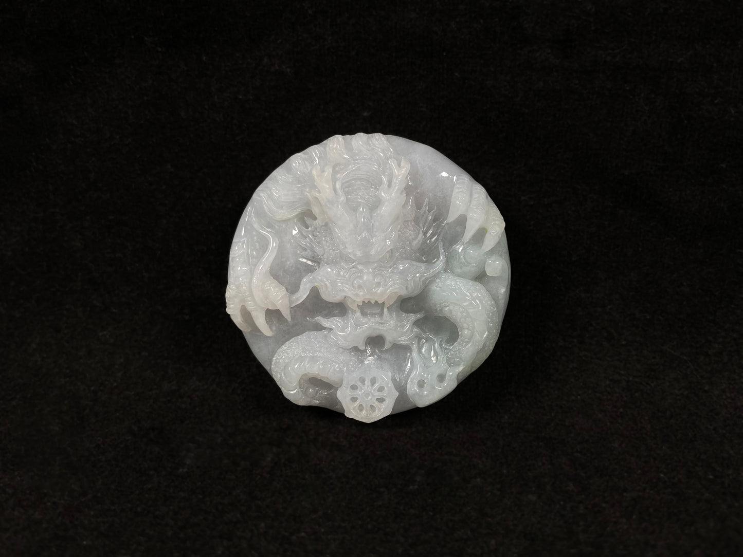 A creamy white jadeite disc carved with a dragon.