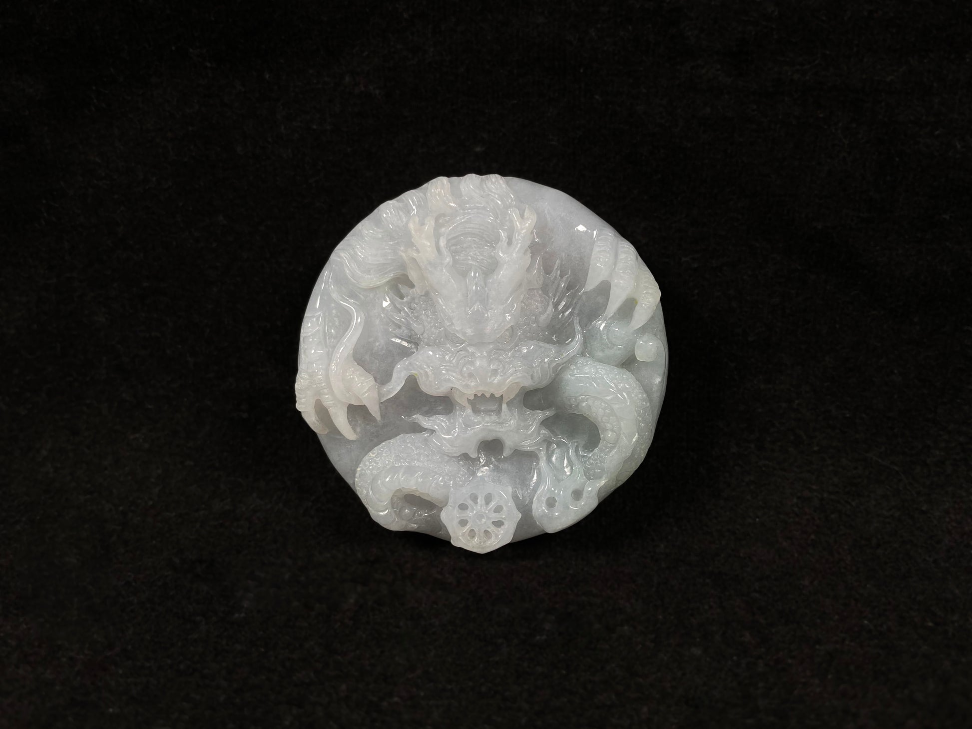 A creamy white jadeite disc carved with a dragon.