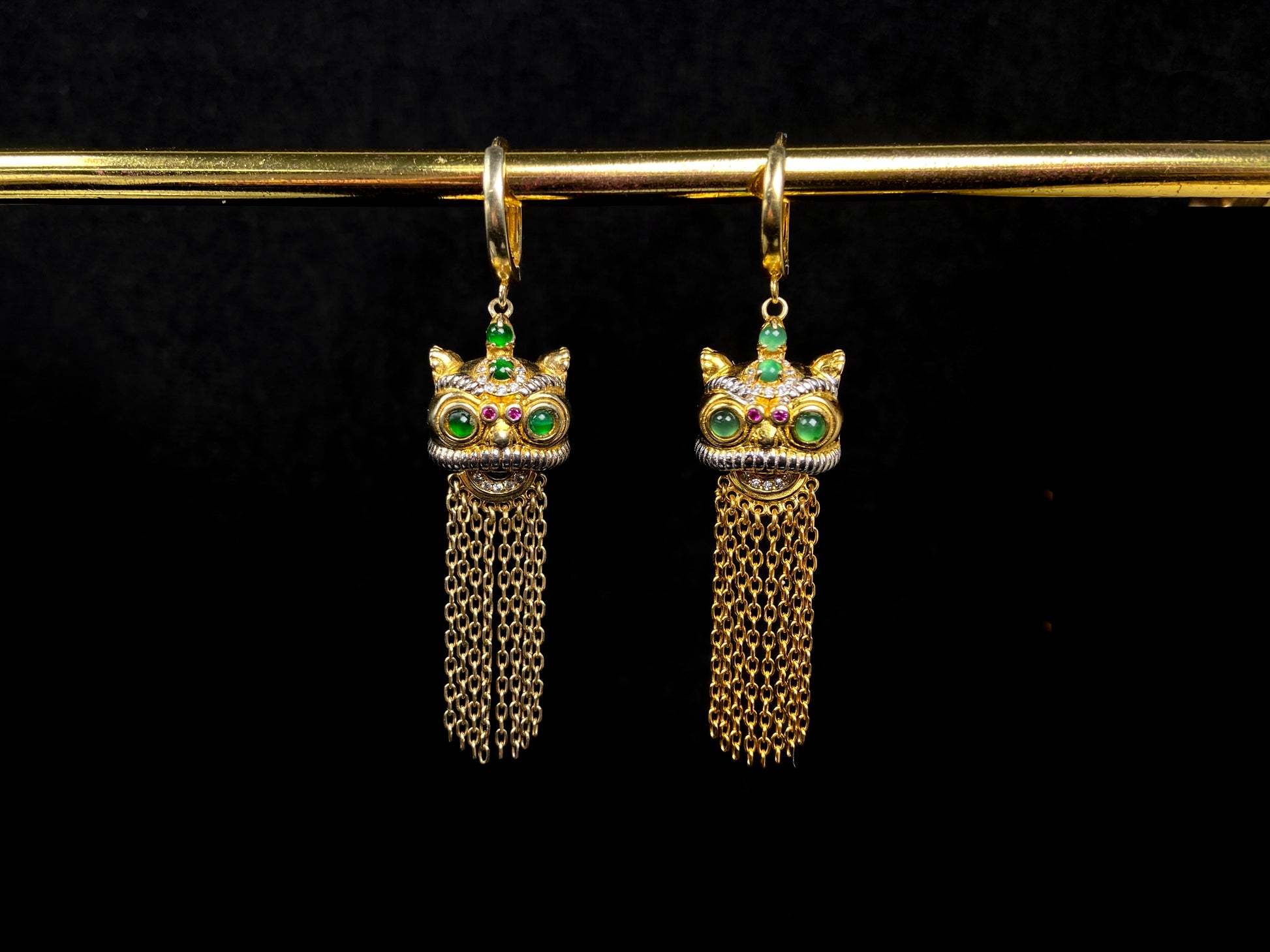 A golden Foo Dog green accent jadeite earrings.