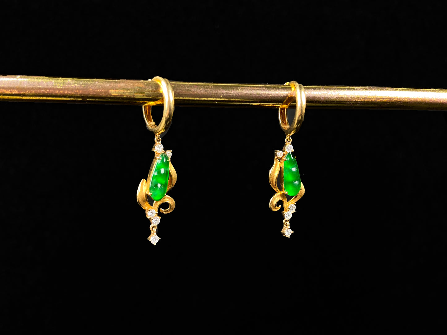 A pair of vivid green snap pea jadeite earrings.