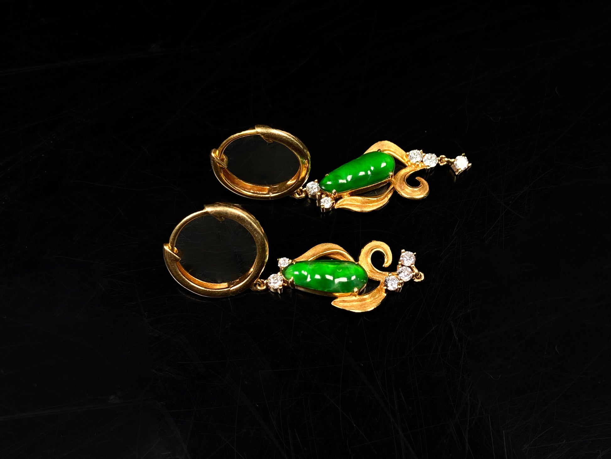 A pair of vivid green snap pea jadeite earrings.