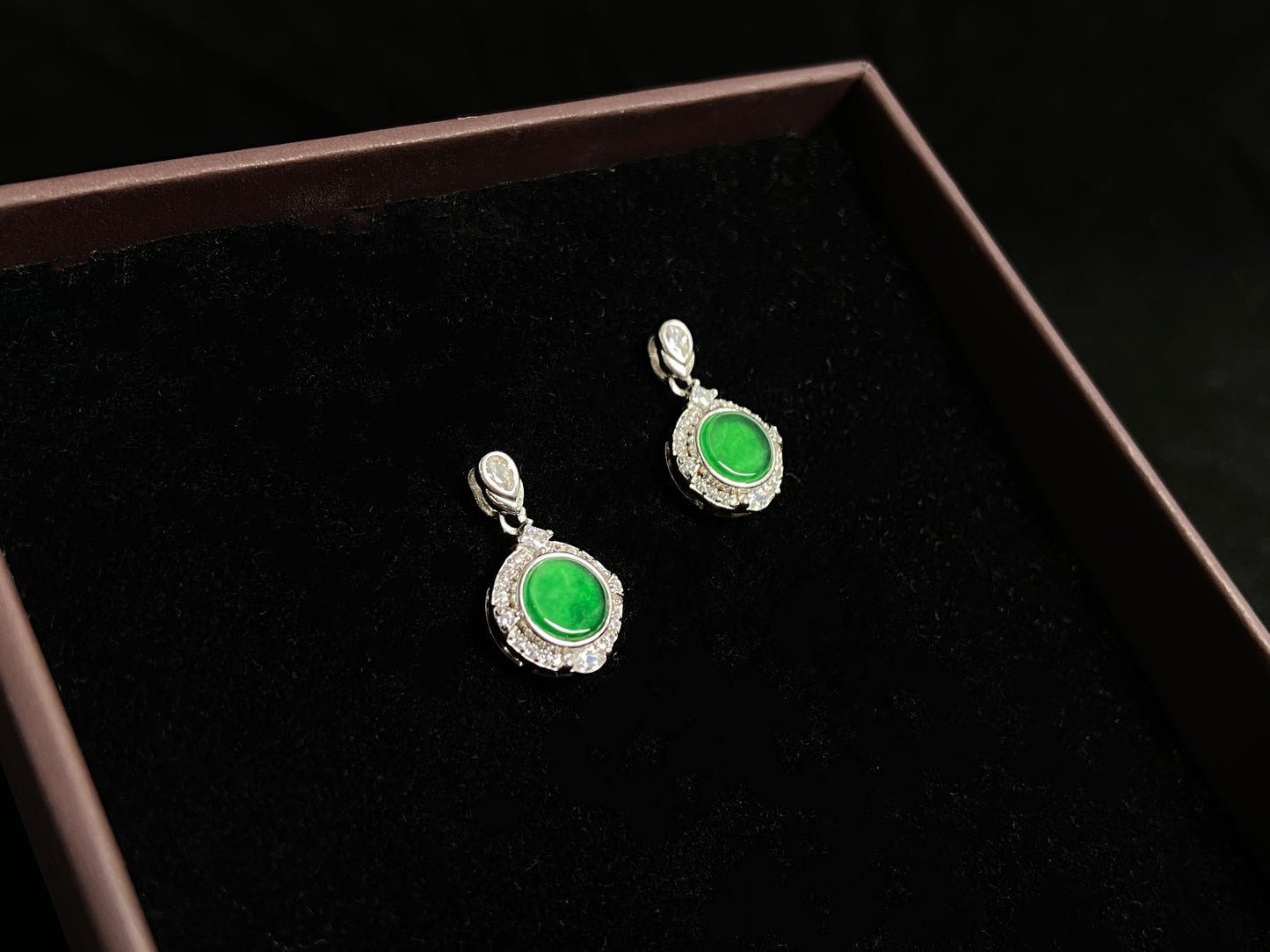 These earrings feature transparent green jade discs elegantly framed in 925 silver.