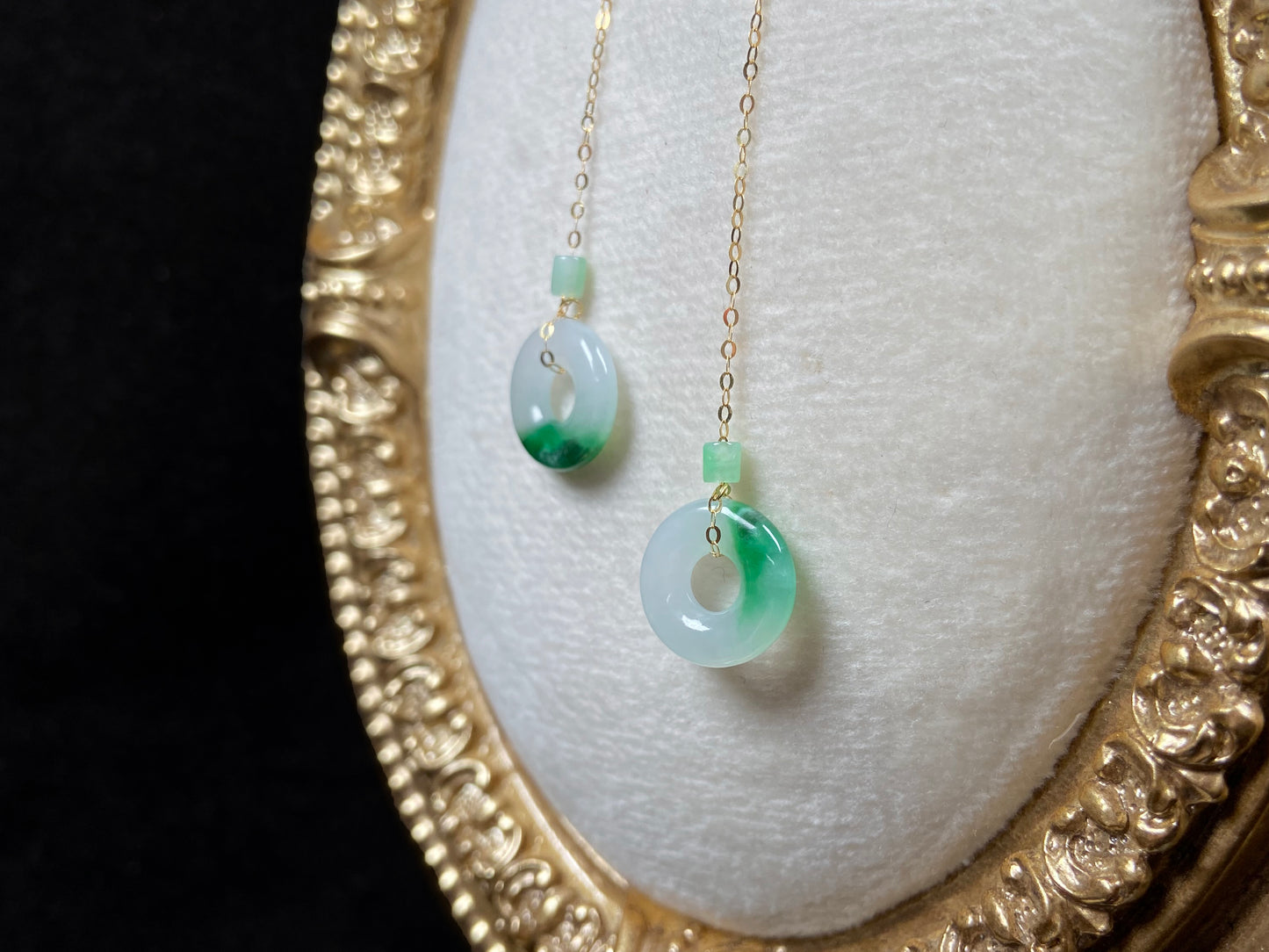 A white green donut jadeite earring.
