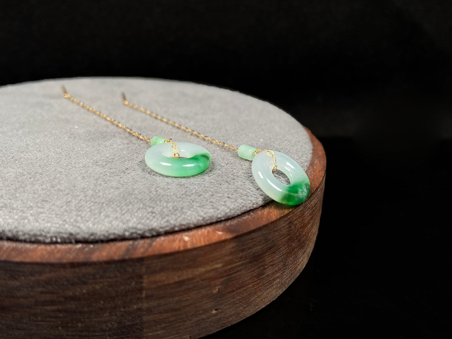 A white green donut jadeite earring.