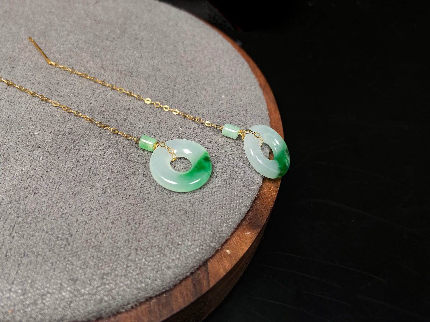 A white green donut jadeite earring.