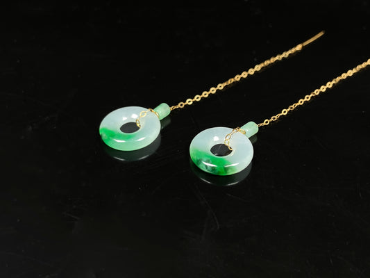 A white green donut jadeite earring.