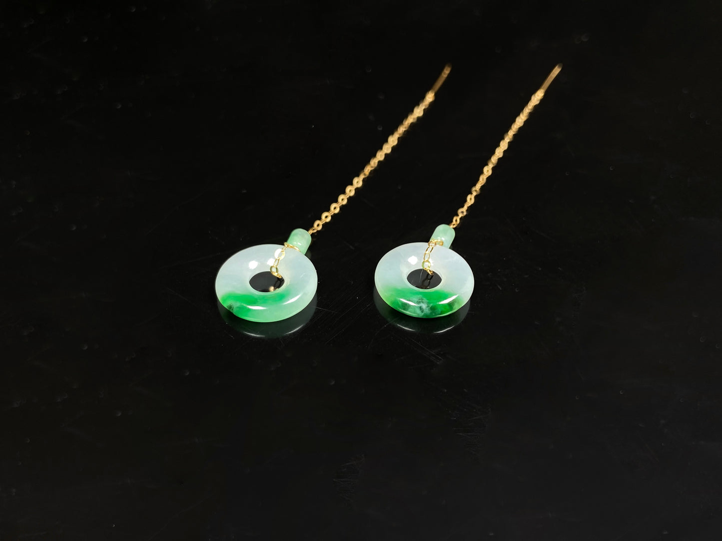 A white green donut jadeite earring.