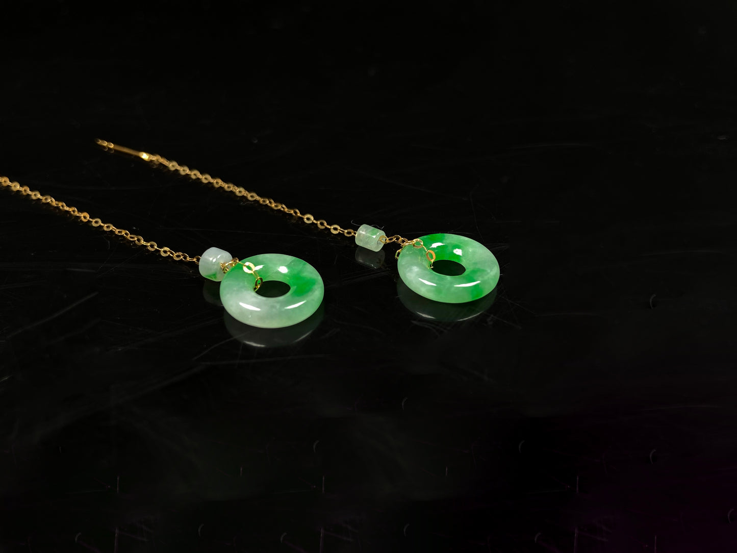A green dew donut and cylinder jadeite earring.