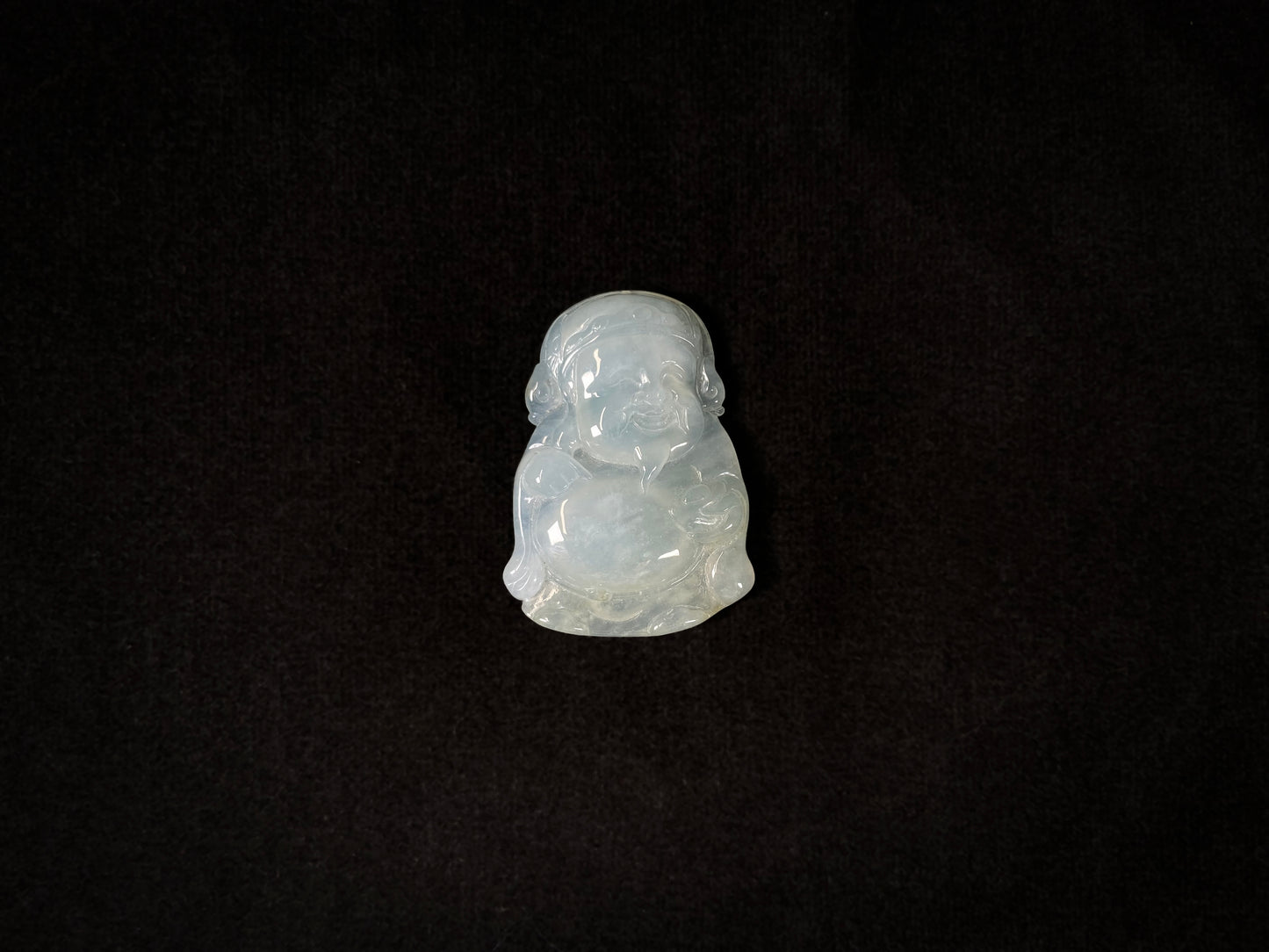 A white ice-colored jadeite carving of the Wealth Deity.