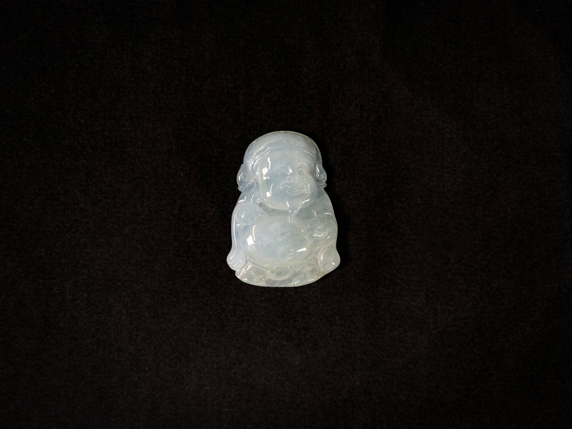A white ice-colored jadeite carving of the Wealth Deity.