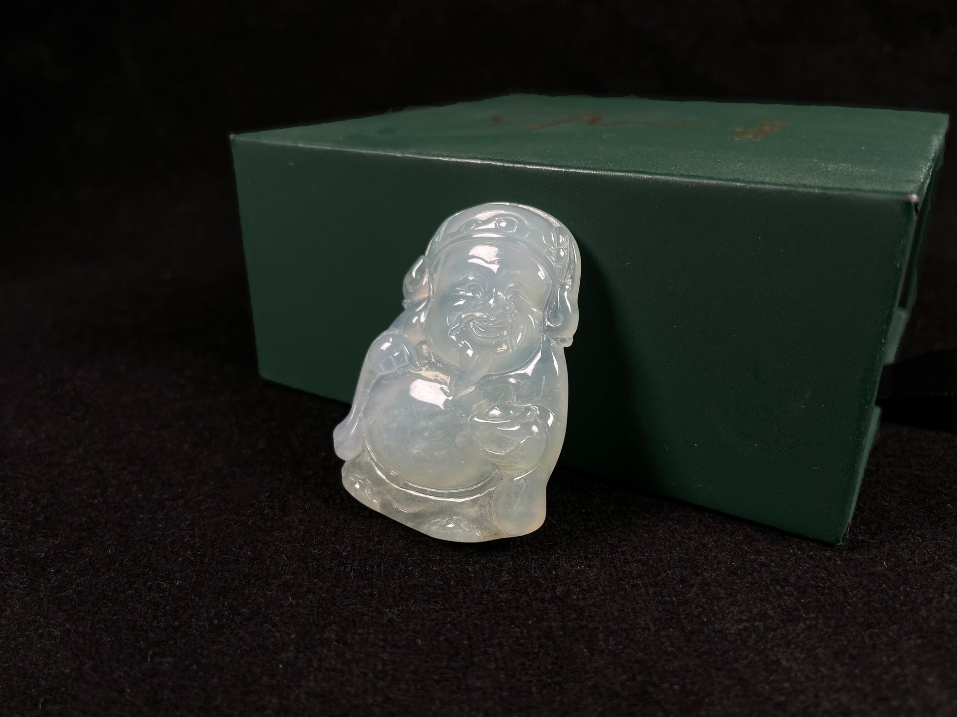 A white ice-colored jadeite carving of the Wealth Deity.
