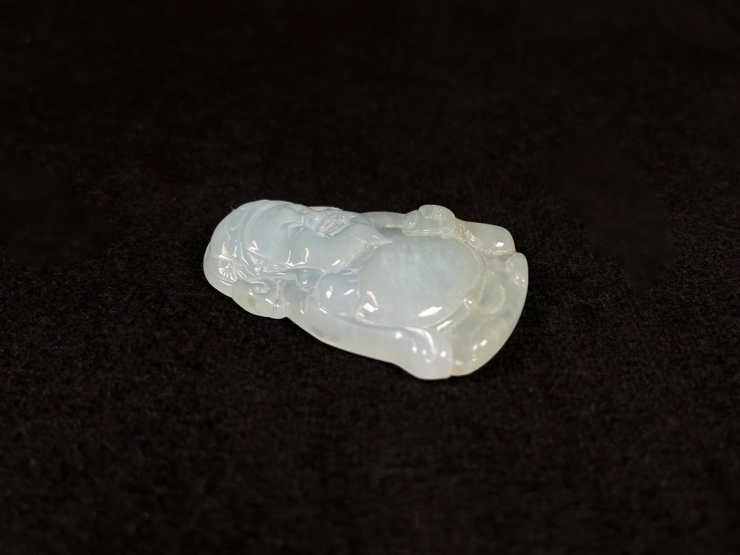 A white ice-colored jadeite carving of the Wealth Deity.