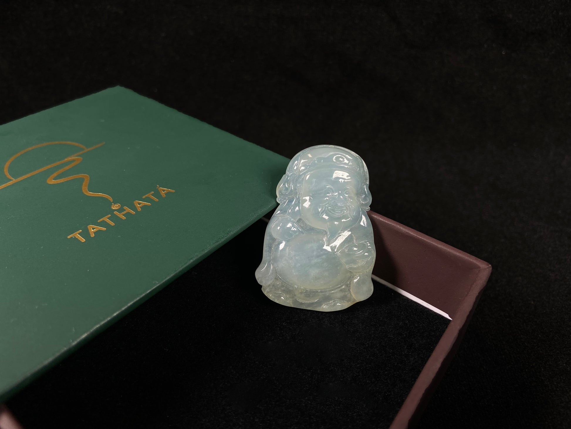 A white ice-colored jadeite carving of the Wealth Deity.