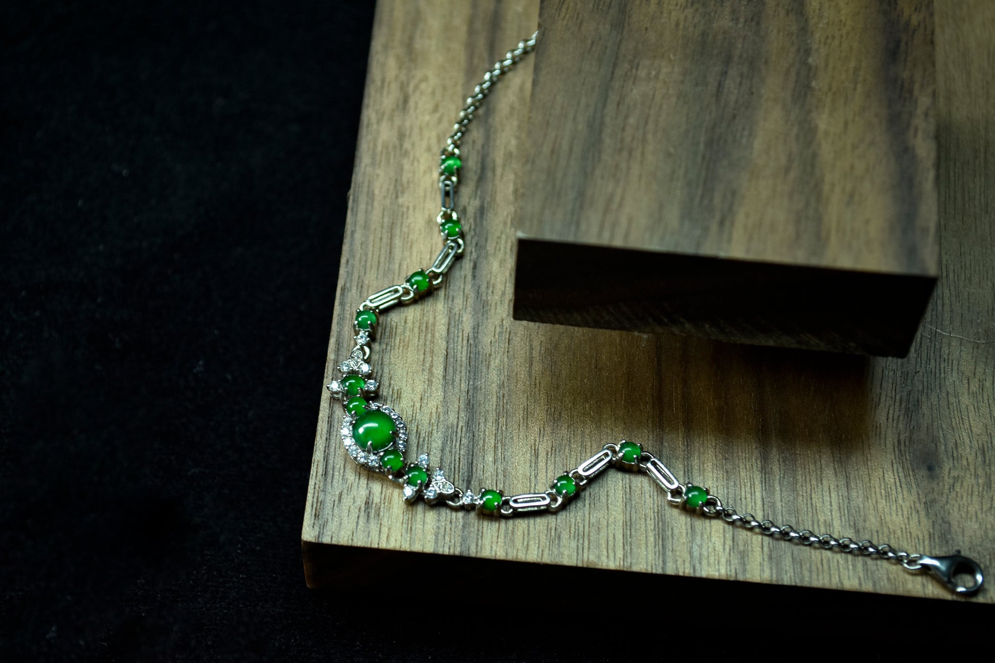 Green beaded bracelet on a wooden block with a dark background