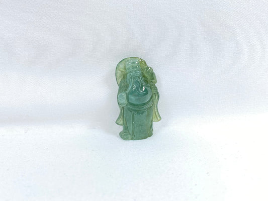 An icy light green jadeite loose stone carving of the God of Wealth.