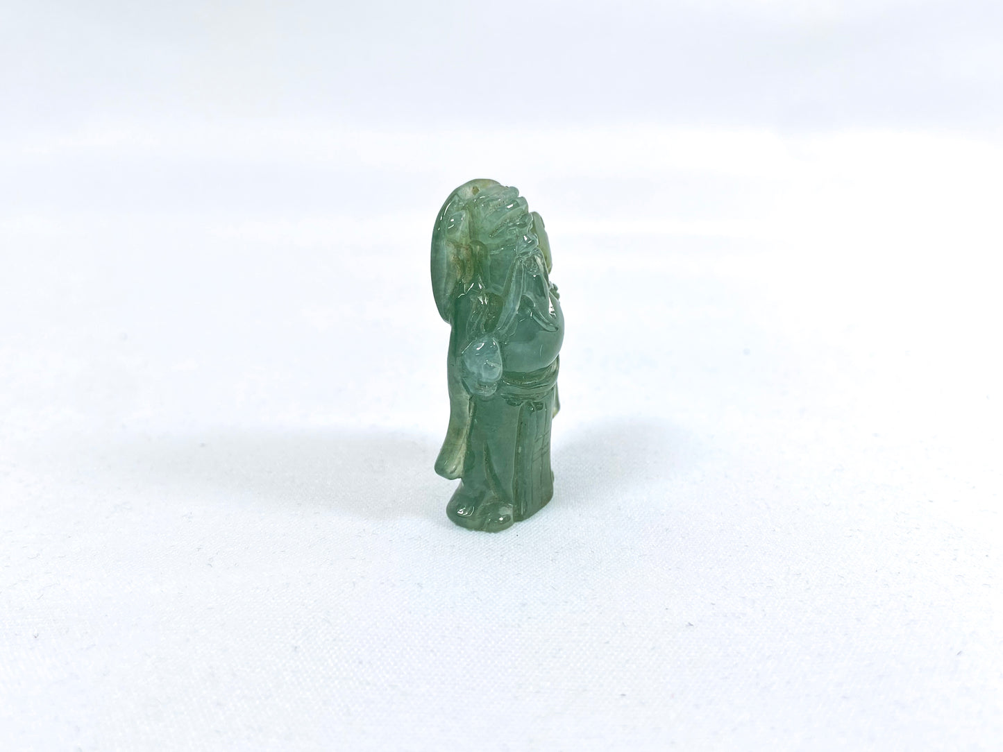 An icy light green jadeite loose stone carving of the God of Wealth.