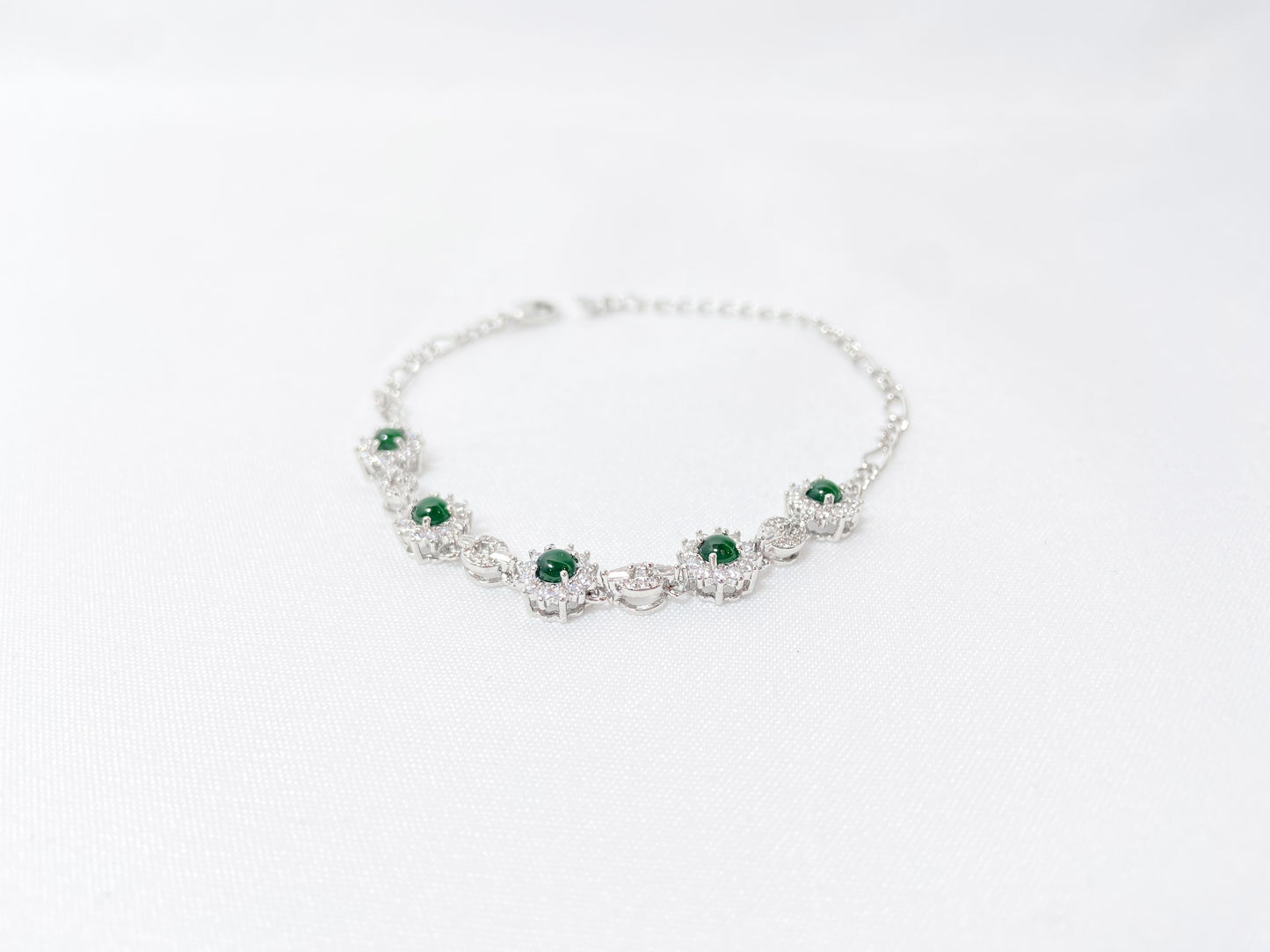 A Guatemalan jade necklace featuring five green beads wrapped in copper settings.