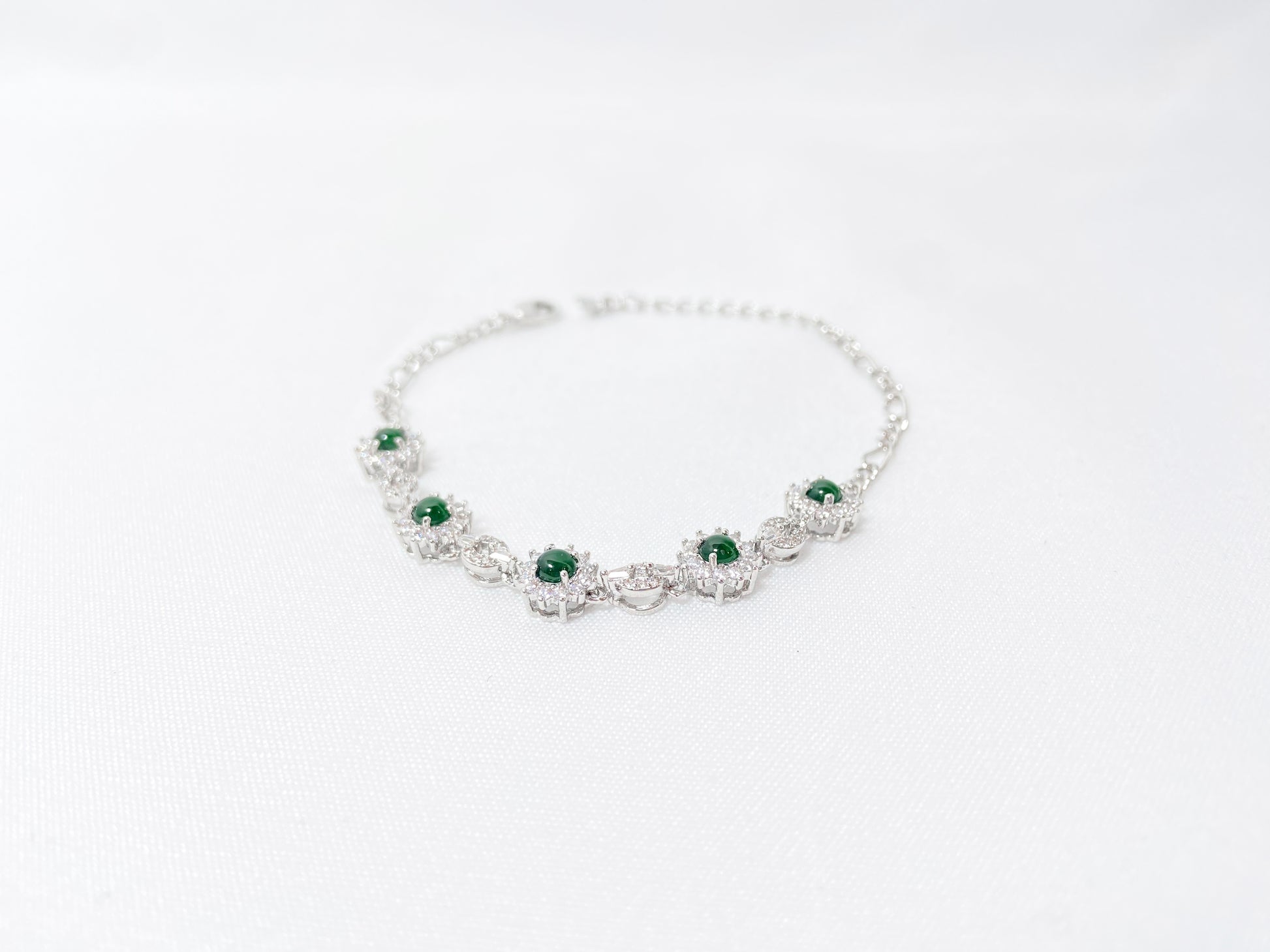 A Guatemalan jade necklace featuring five green beads wrapped in copper settings.