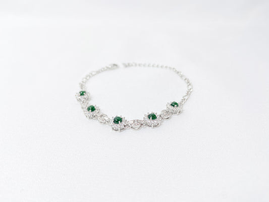 A Guatemalan jade necklace featuring five green beads wrapped in copper settings.