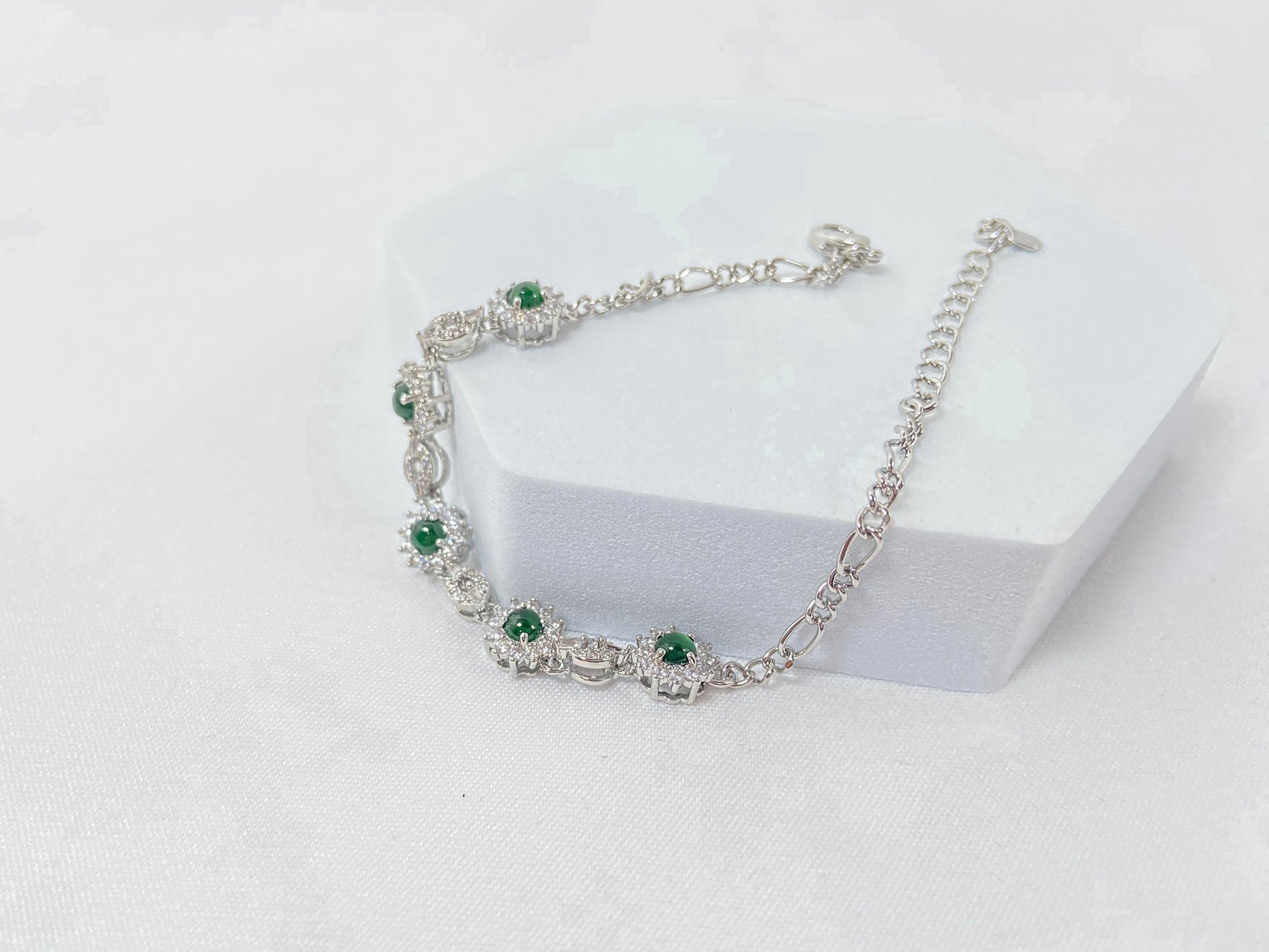 A Guatemalan jade necklace featuring five green beads wrapped in copper settings.