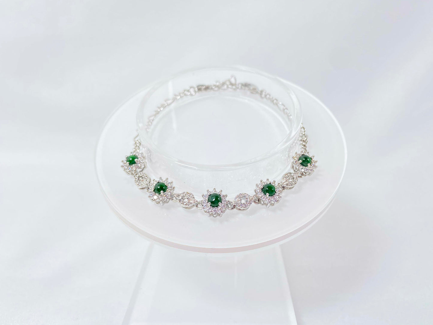 A Guatemalan jade necklace featuring five green beads wrapped in copper settings.