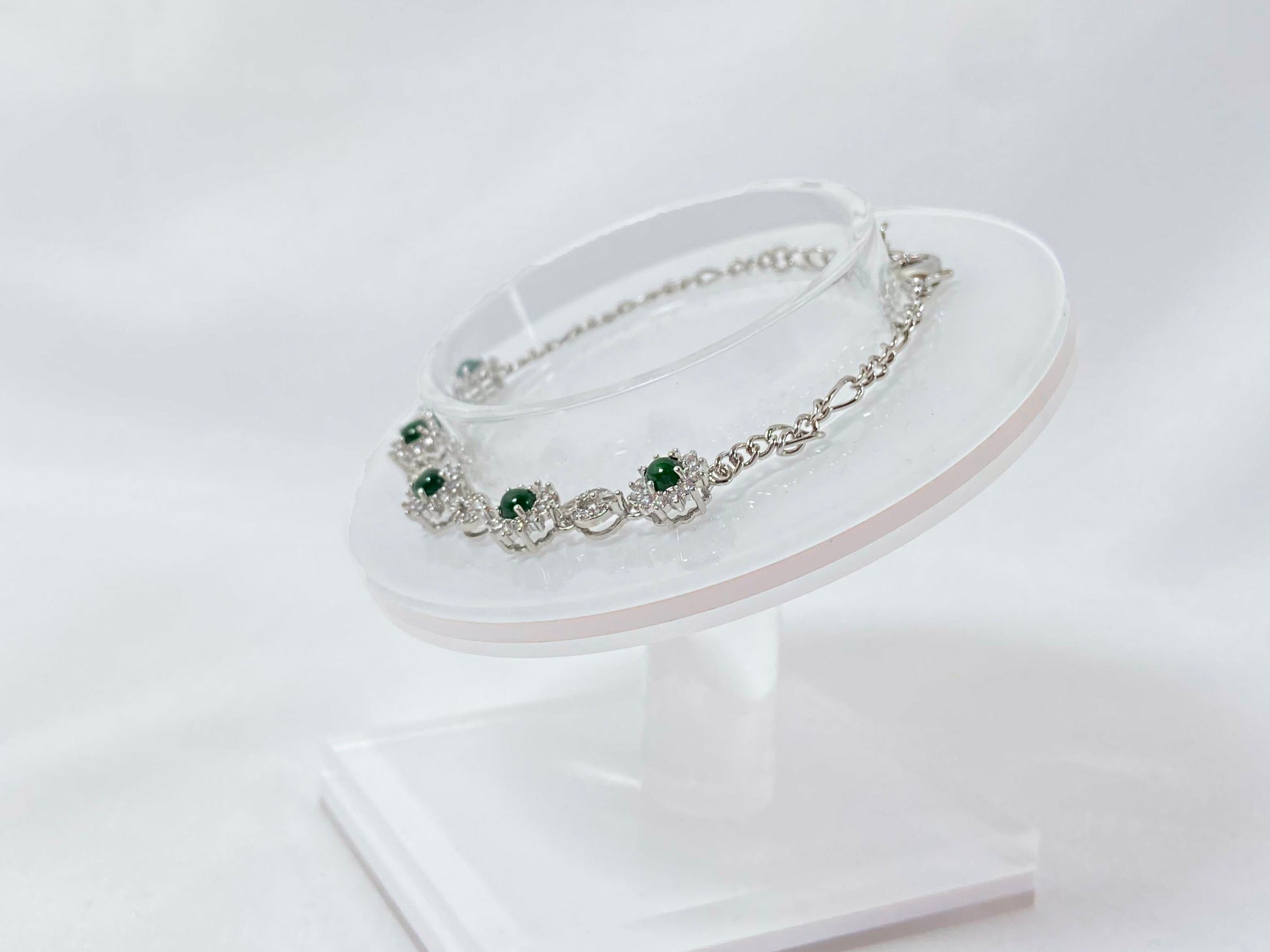 A Guatemalan jade necklace featuring five green beads wrapped in copper settings.