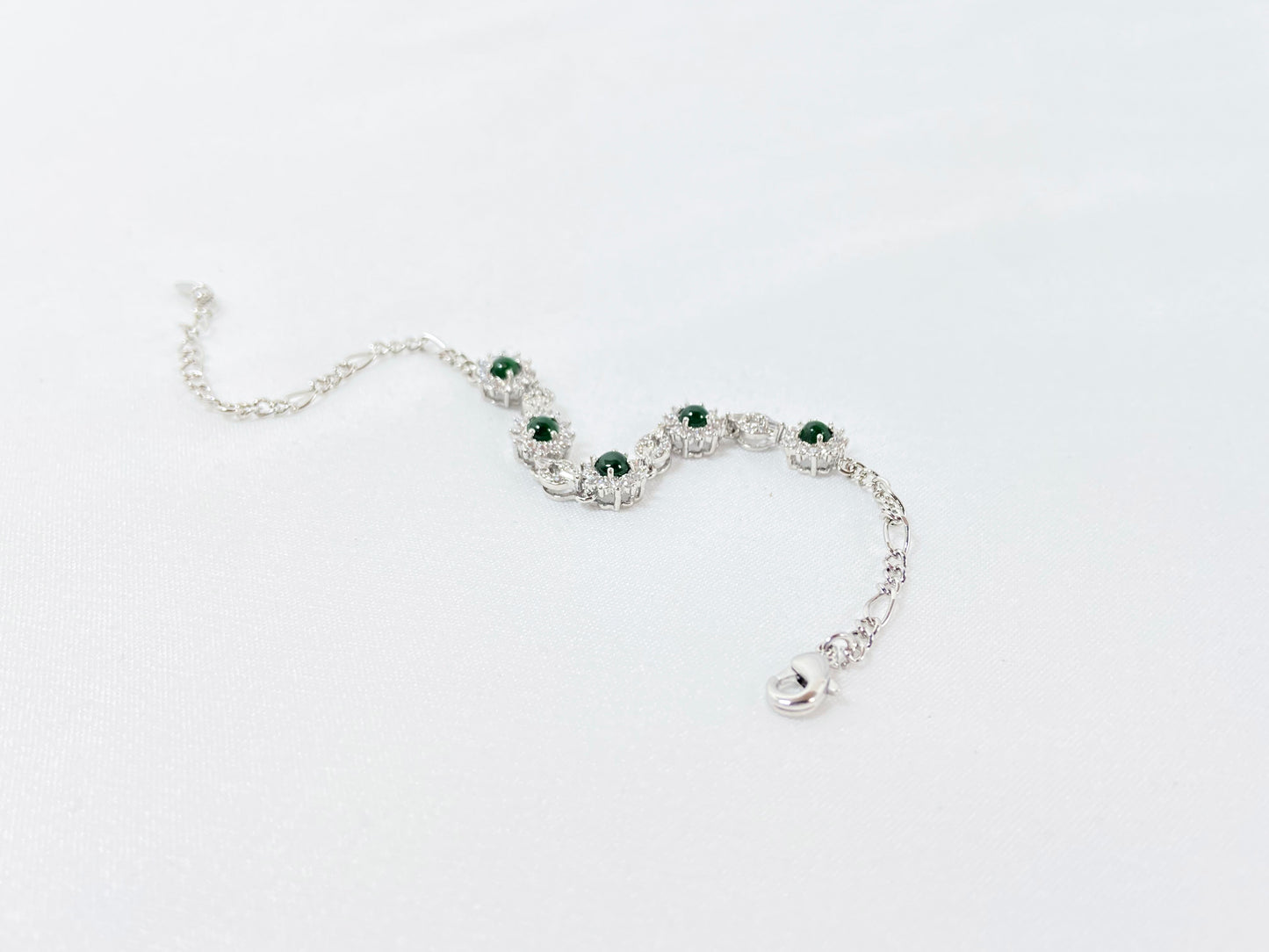 A Guatemalan jade necklace featuring five green beads wrapped in copper settings.