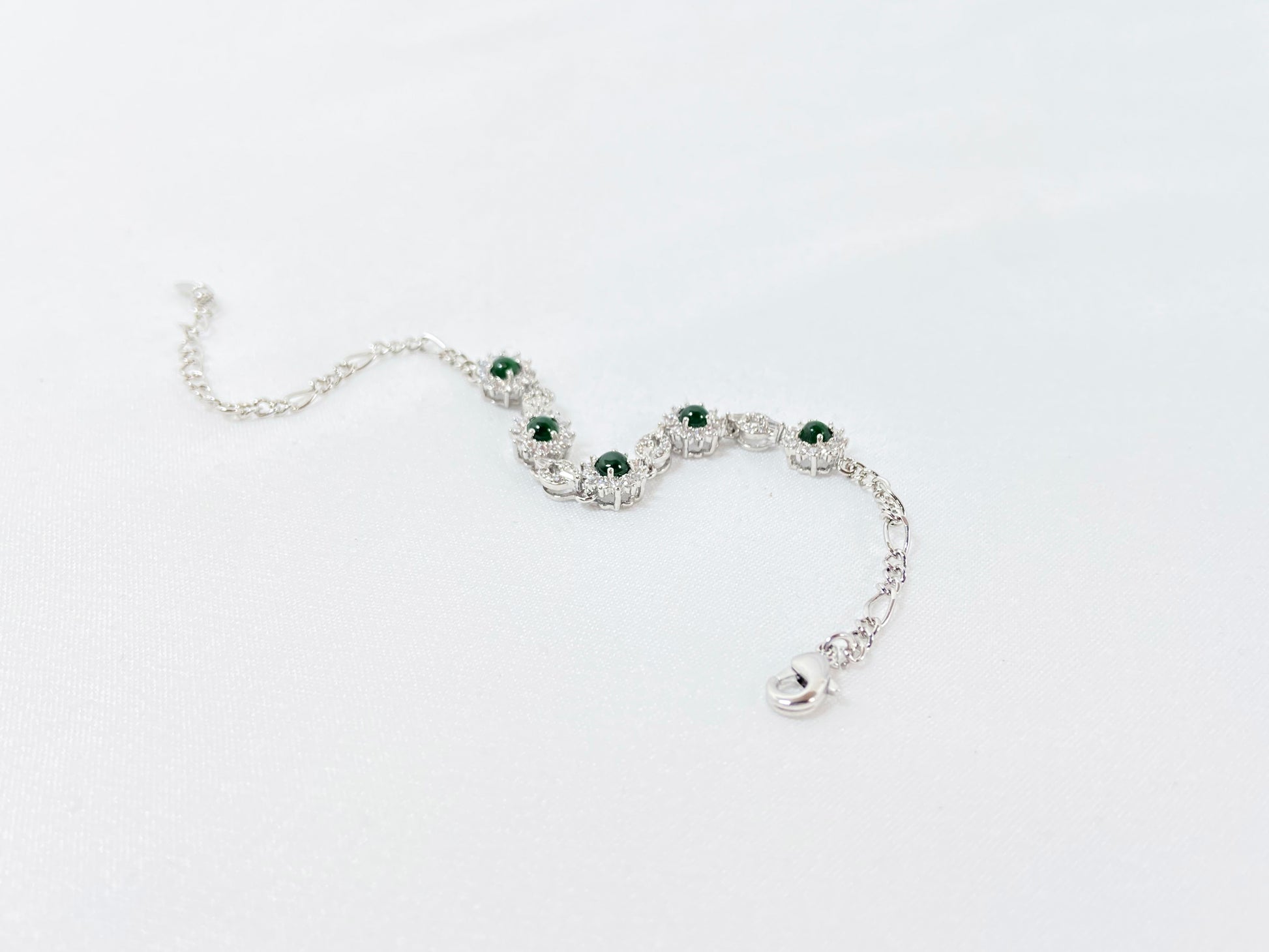 A Guatemalan jade necklace featuring five green beads wrapped in copper settings.