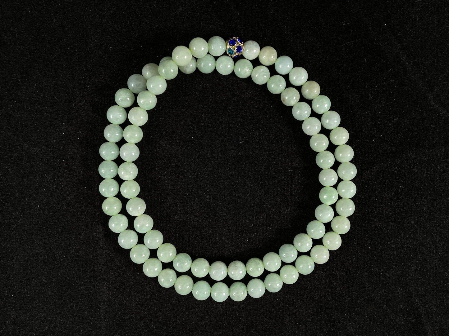 A jade bead strand in a pale whitish green hue.