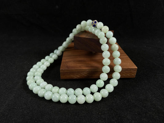 A jade bead strand in a pale whitish green hue.