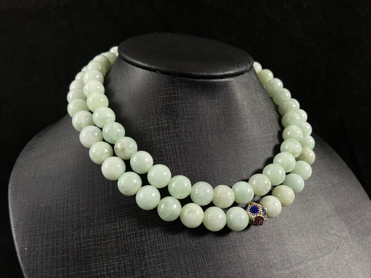 A jade bead strand in a pale whitish green hue.