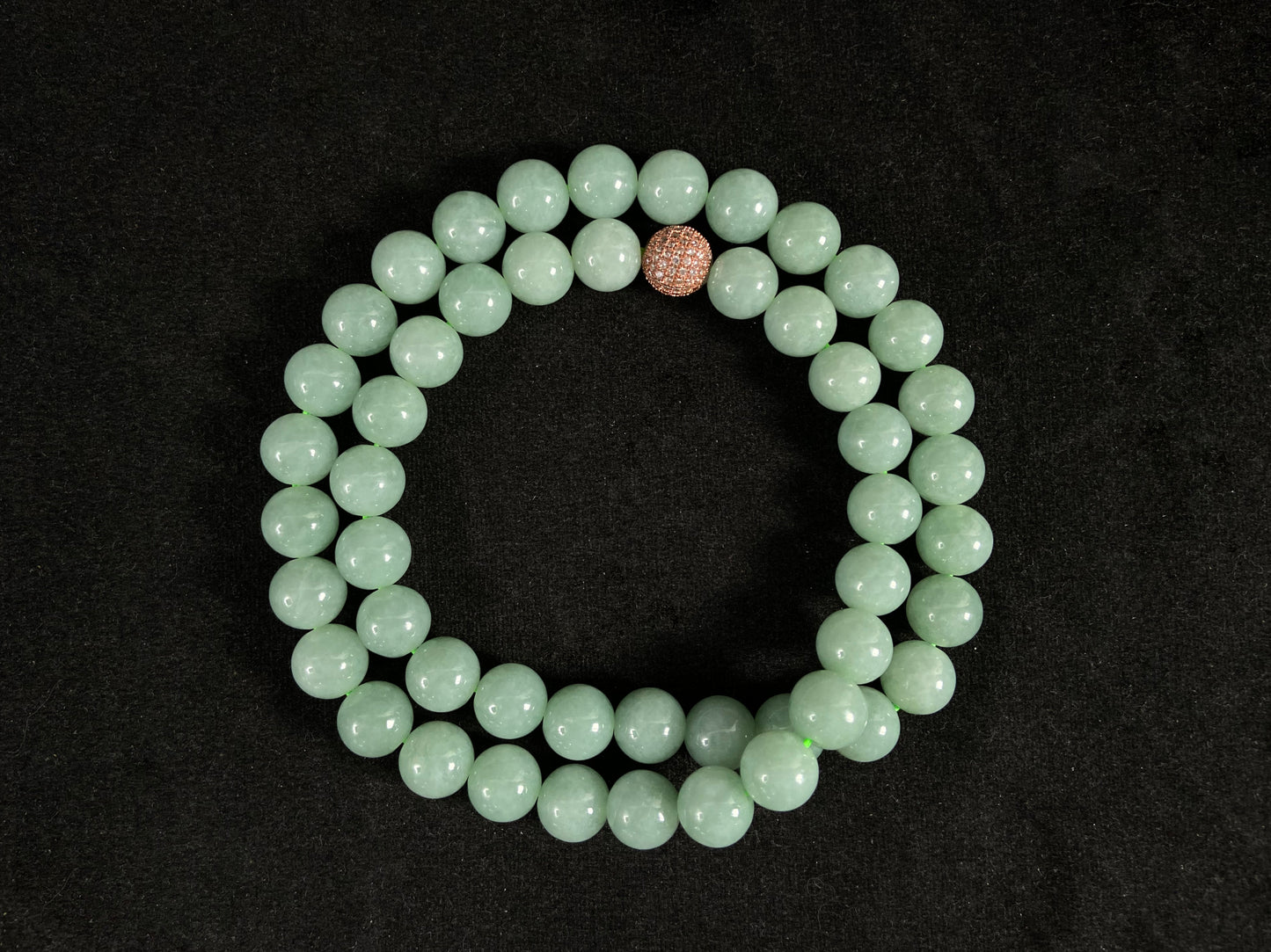 A jade bead strand featuring a gold mesh focal bead amid apple green beads.