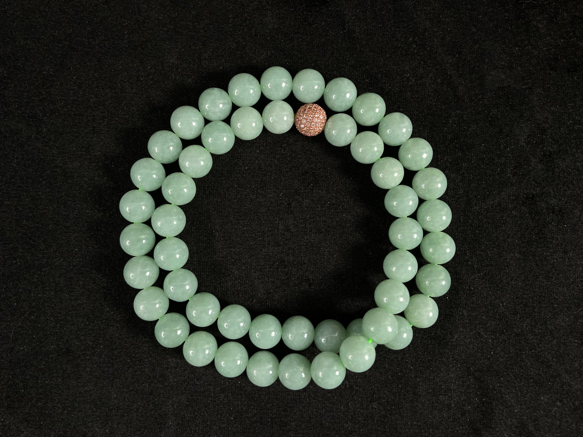 A jade bead strand featuring a gold mesh focal bead amid apple green beads.
