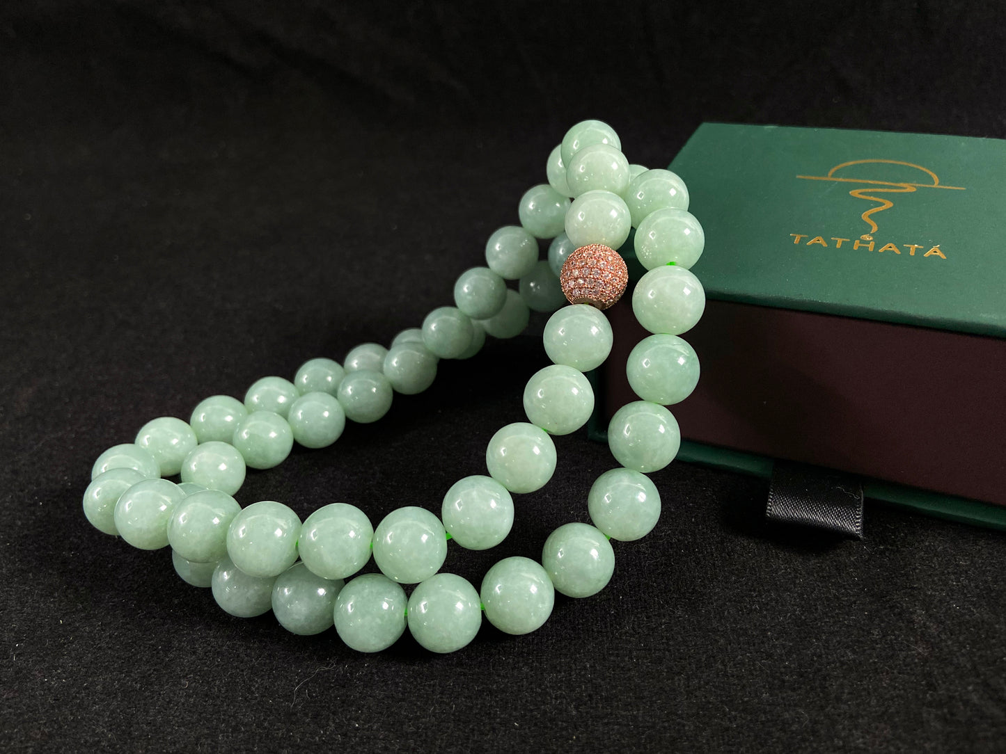 A jade bead strand featuring a gold mesh focal bead amid apple green beads.