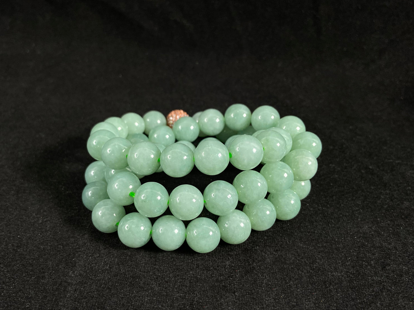 A jade bead strand featuring a gold mesh focal bead amid apple green beads.