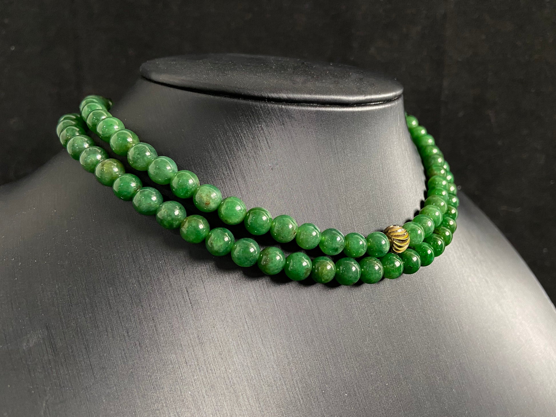 This elegant jade necklace combines spinach green beads with a silver gold plated focal bead, creating a perfect balance of natural beauty and metallic elegance.