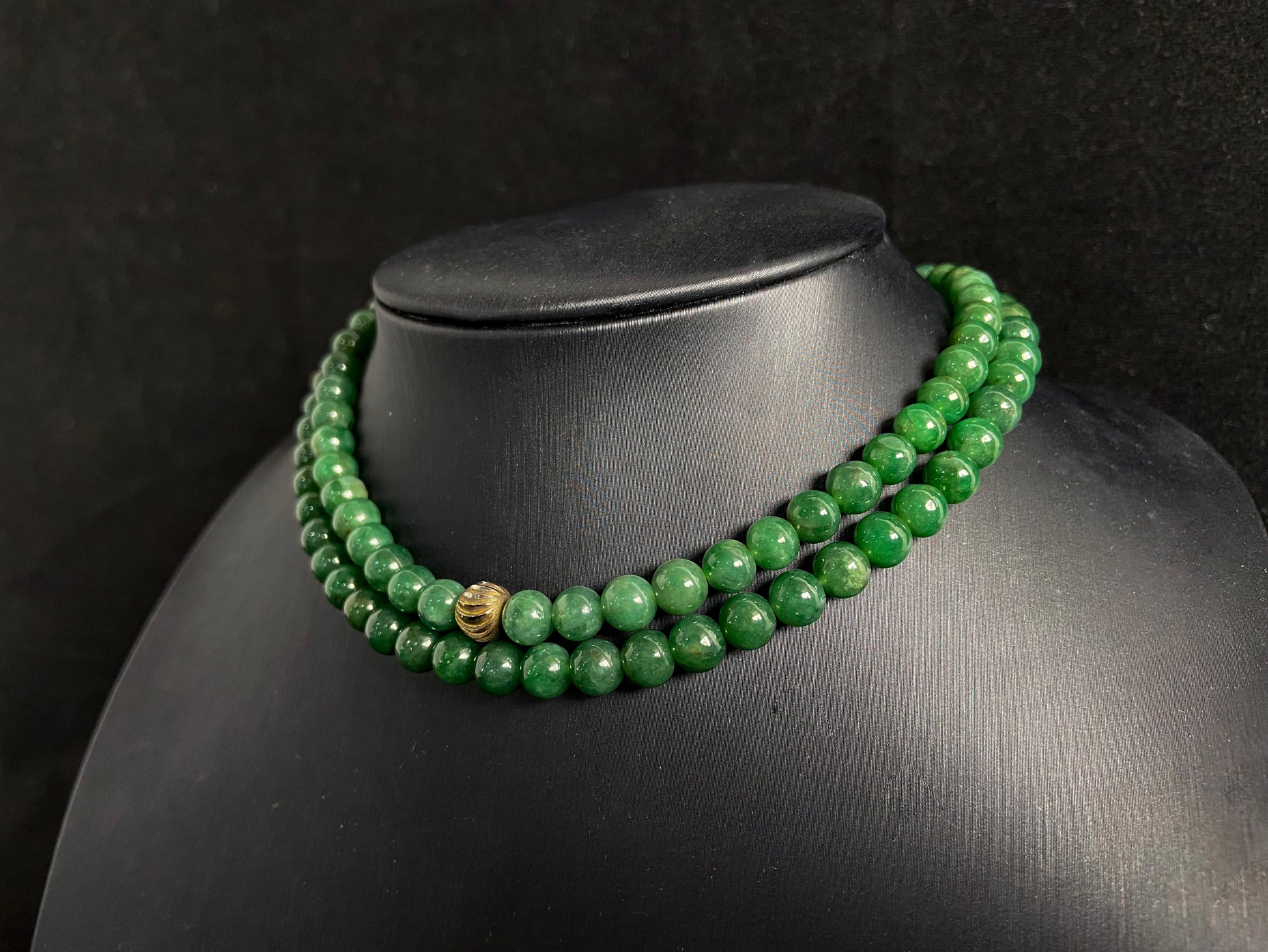 This elegant jade necklace combines spinach green beads with a silver gold plated focal bead, creating a perfect balance of natural beauty and metallic elegance.