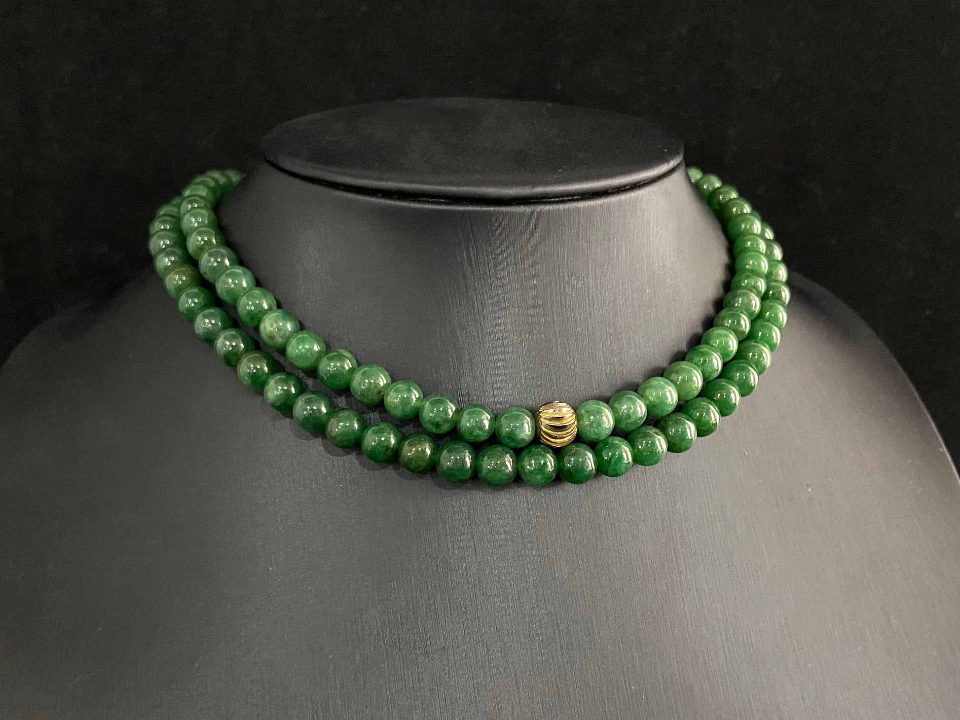 This elegant jade necklace combines spinach green beads with a silver gold plated focal bead, creating a perfect balance of natural beauty and metallic elegance.
